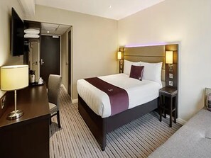 A hotel room with a bed, bedside tables, a desk, a chair, and a TV mounted on the wall. - Premier Inn Portsmouth Havant South (Havant)