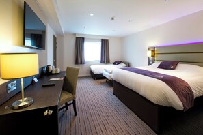 A hotel room with a bed, a desk, a chair, a TV, and a window with curtains. - Premier Inn Portsmouth Havant South (Havant)