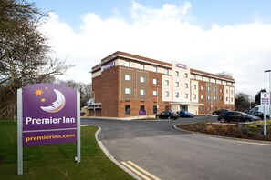 A Premier Inn hotel with a signboard, a parking area, and a building with multiple windows. - Premier Inn Portsmouth Havant South (Havant)