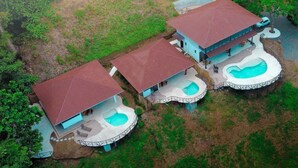 A resort with three buildings, each with a swimming pool and a covered patio area.