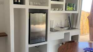 Una cocina compacta con electrodomésticos integrados, una mesa de comedor y vistas al exterior.
