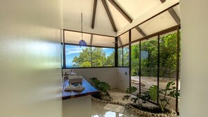 Una habitación moderna con un ventanal amplio, un escritorio de madera y una planta en maceta.
