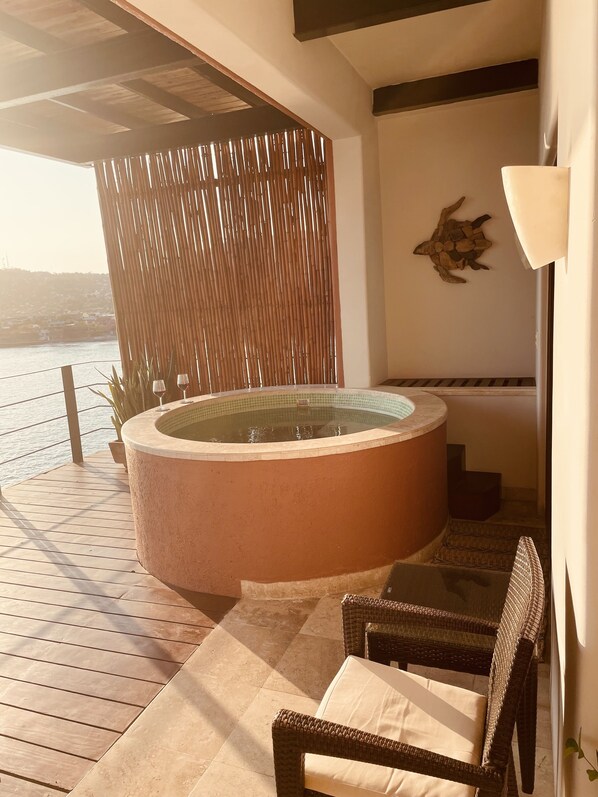 A spa area with a hot tub, wicker chairs, and a view of the water. - Panoramic Bay Views•Private Plunge Pool•Walk to La Ropa Beach (Zihuatanejo)