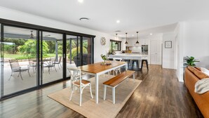 Una cocina moderna con armarios blancos, una isla central e iluminación colgante.
