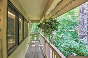Step out onto the covered porch and take in the serene views of the lush forest surroundings.