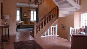 A spacious living area with a wooden staircase, a chandelier, and a sofa set. - ARTHUR Historic vacation home Moselle (Mülheim (Mosel))
