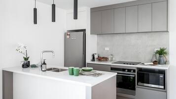 A modern kitchen with a central island, stainless steel appliances, and a minimalist design.