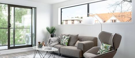 Una sala de estar moderna con un sofá, un sillón y una mesa de centro.