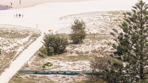 A beach with a clear view of the ocean, a sandy path leading to the water, and sparse vegetation. - Club Wyndham Kirra Beach, Trademark Collection by Wyndham (Coolangatta)