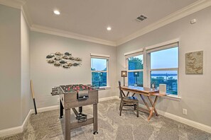 Relax in a spacious room with a desk and foosball table, offering a view of the outdoors.
