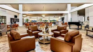 A spacious lobby with leather sofas, a round coffee table, and a grand piano. - Relaxing desert retreat with amazing mountain and lake view on the 7th fairway! (Palm Desert)