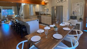 A modern kitchen with a central island, white cabinetry, and a chandelier.