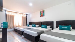 A hotel room with three beds, a desk, and a painting on the wall. - Ayenda Oporto Suites (San José de Cúcuta)