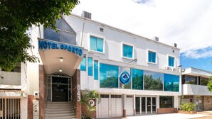 A hotel named "HOTEL OPORTO" with a modern facade, large windows, and a visible entrance. - Ayenda Oporto Suites (San José de Cúcuta)