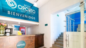 A hotel reception area with a blue sign reading "Hotel Oporto Suites Cucuta" and "Bienvenidos". - Ayenda Oporto Suites (San José de Cúcuta)