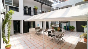 A spacious indoor courtyard with a checkered floor, multiple seating areas, and potted plants. - Ayenda Oporto Suites (San José de Cúcuta)