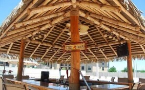 Relax in the Tiki Bar, where guests can enjoy outdoor dining and socializing under a thatched roof.