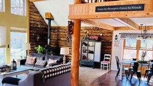 Amplia sala de estar con un sofá grande, piso de madera y un entrepiso decorado con una figura de jirafa.