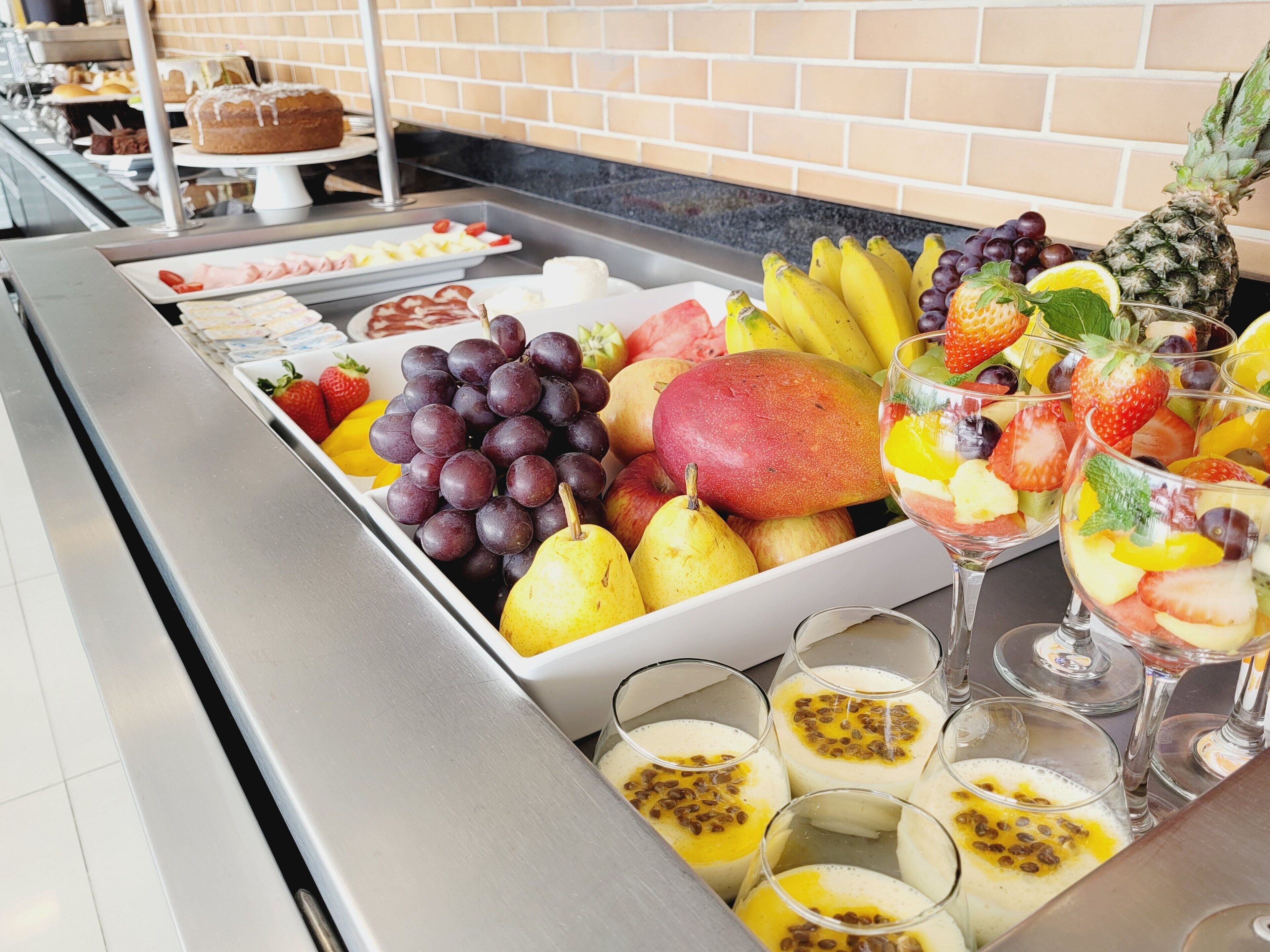 A buffet with a variety of fruits and desserts.