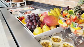 A buffet with a variety of fruits and desserts.