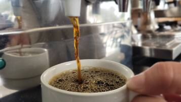 Una cafetera sirviendo café en una taza.