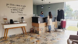 Un área de recepción con suelo de baldosas, un mostrador y una pared con una cita.