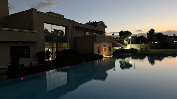 A swimming pool with a modern building in the background.
