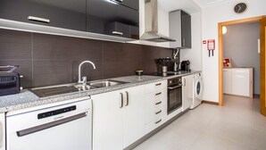 A modern kitchen with stainless steel appliances, a dishwasher, and a built-in oven.
