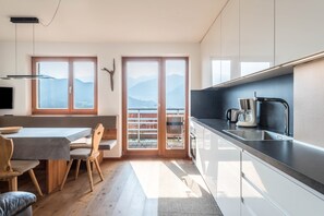 Eine moderne Küche mit Essbereich, großen Fenstern und Bergblick.