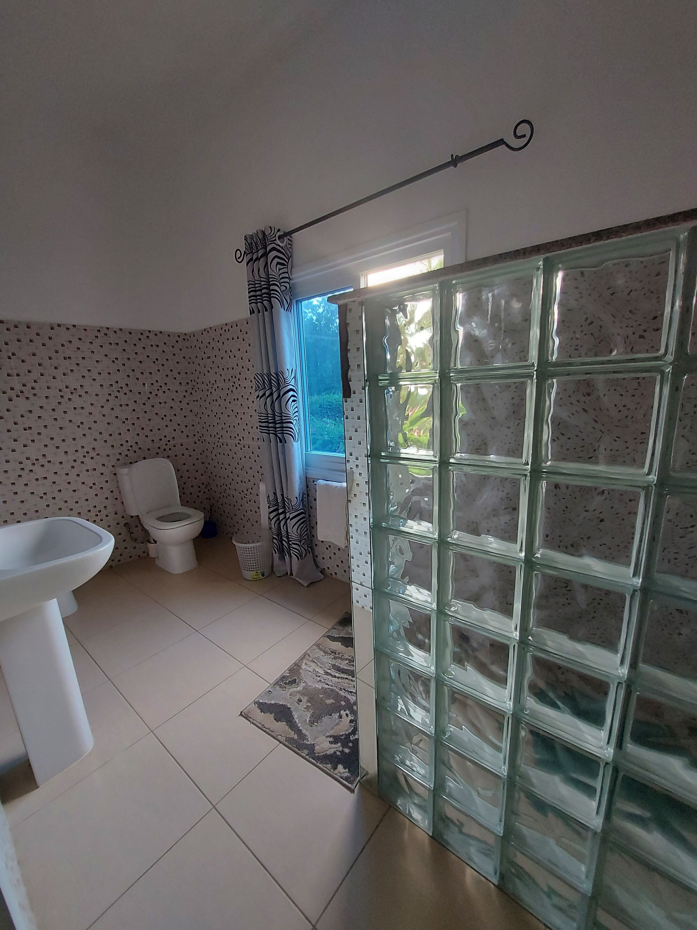 Et badeværelse med toilet, vask og bruser.