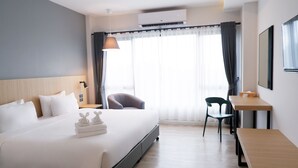 A modern hotel room with a large bed, a desk, and a chair. - bliQ Hotel Chanthaburi (Chanthaburi)