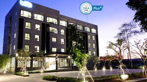 A modern hotel building with multiple floors, large windows, and a well-lit entrance area. - bliQ Hotel Chanthaburi (Chanthaburi)