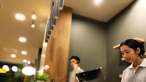 A modern hotel reception area with a counter, a plant, and a laptop. - bliQ Hotel Chanthaburi (Chanthaburi)