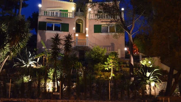 Ein zweistöckiges Gebäude mit Balkon, Treppe und einer Tür.