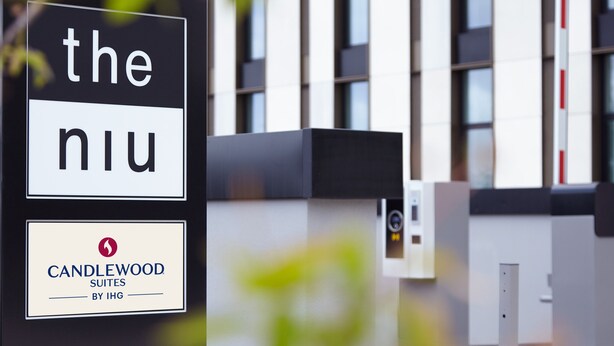 A sign for "The Niu" hotel with a logo for Candlewood Suites by IHG. - Holiday Inn - the niu, Hub Dusseldorf Messe by IHG (Düsseldorf)