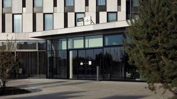 Een modern gebouw met grote glasramen en een bord waarop 'The Niu' staat.