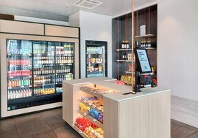 Un'area commerciale moderna con espositori refrigerati per bevande e scaffali per snack.