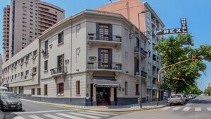 Un hotel de estilo arquitectónico clásico, con un llamativo cartel de marquesina, varios balcones y una entrada en esquina.