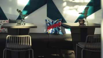 A modern interior with a geometric wall design, a table with a decorative pillow, and a chair.