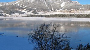 Une montagne enneigée, avec une station de ski en arrière-plan.