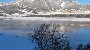 A snow-covered mountain with a ski resort in the background.