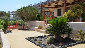 A patio area with a pergola, potted plants, and a seating area.