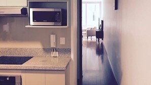 A modern kitchen with built-in appliances, a microwave, and a coffee machine. - Stunningly Beautiful & Modern Apt. Small building (Miraflores)