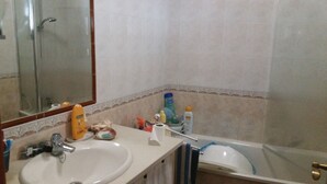 A bathroom with a sink, mirror, and bathtub. - Villa with terrace, beaches nearby as well as Évora - museum city.   (Torrao)