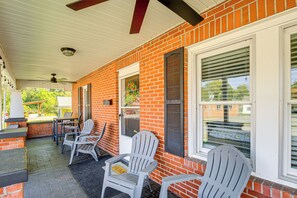A covered patio with brick walls, white shutters, and two Adirondack chairs. - 'Trout House' in Dtwn Damascus: Near Creeper Trail (Damascus)