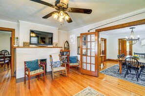 A spacious living room with hardwood flooring, a fireplace, and a dining area with wooden furniture. - 'Trout House' in Dtwn Damascus: Near Creeper Trail (Damascus)