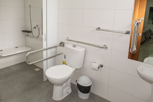 A modern bathroom with a white toilet, a bidet, a hand dryer, and a grab bar. - Tri Hotel Centro Chapeco (Chapecó)