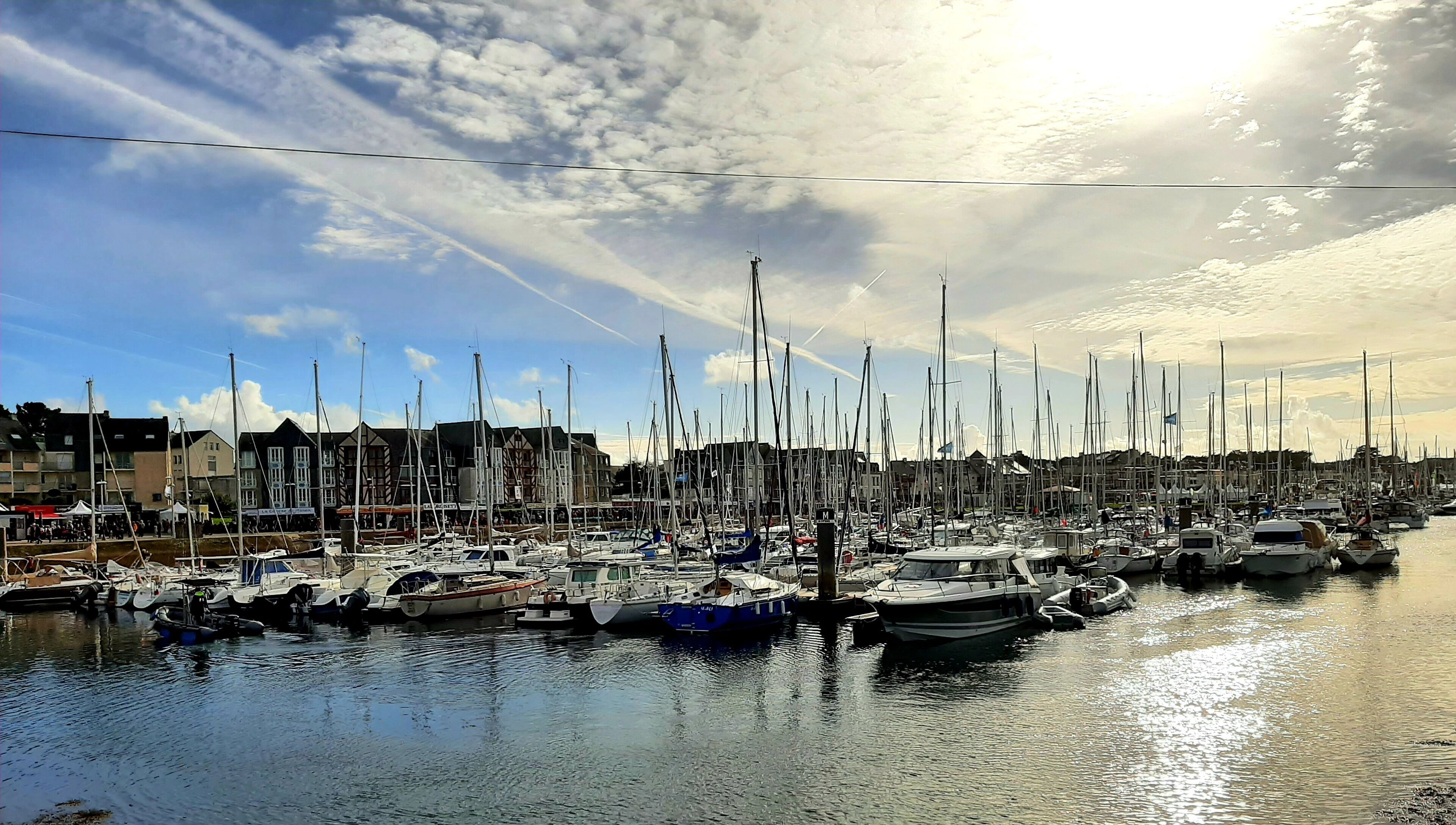 A marina with numerous boats docked, surrounded by buildings.