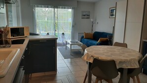 Ein kompakter Wohnraum mit Küchenzeile, Essbereich und einer Couch.