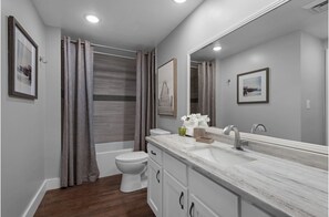 Een bad/douchecombinatie, een haardroger, handdoeken